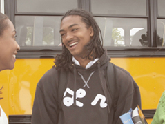 Young adult standing in front of bus