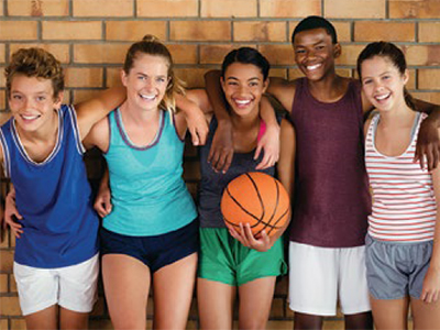 5 teenage friends with their arms around each other, and one person holding a basketball