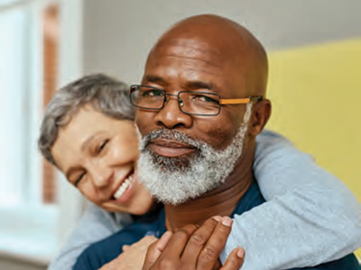 Man with woman behind him with arms around him