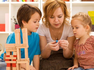 Mother working with two young children on a puzzle
